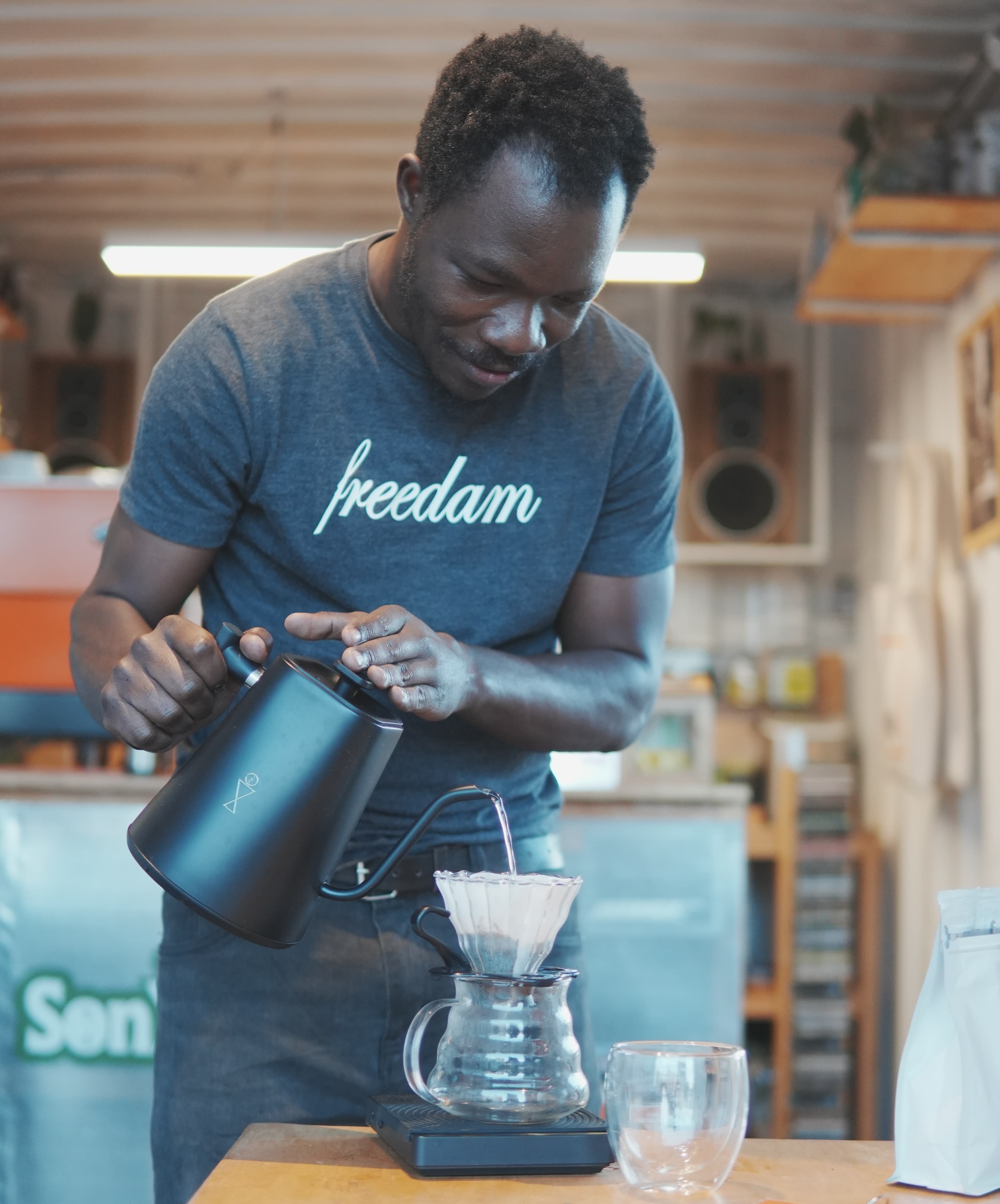 A Sonique barista pouring a V60 pour-over