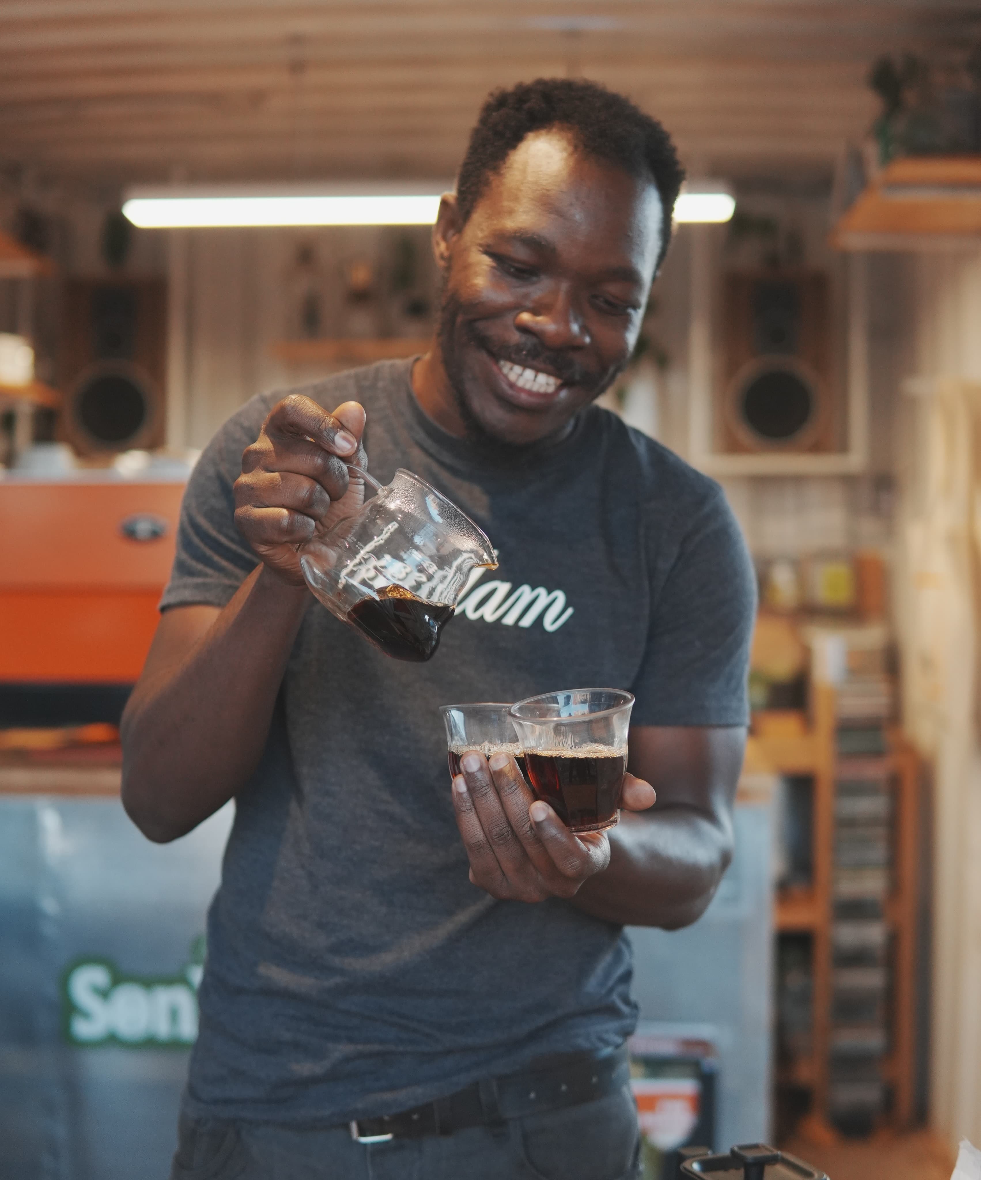 A Sonique barista smiling behind the bar