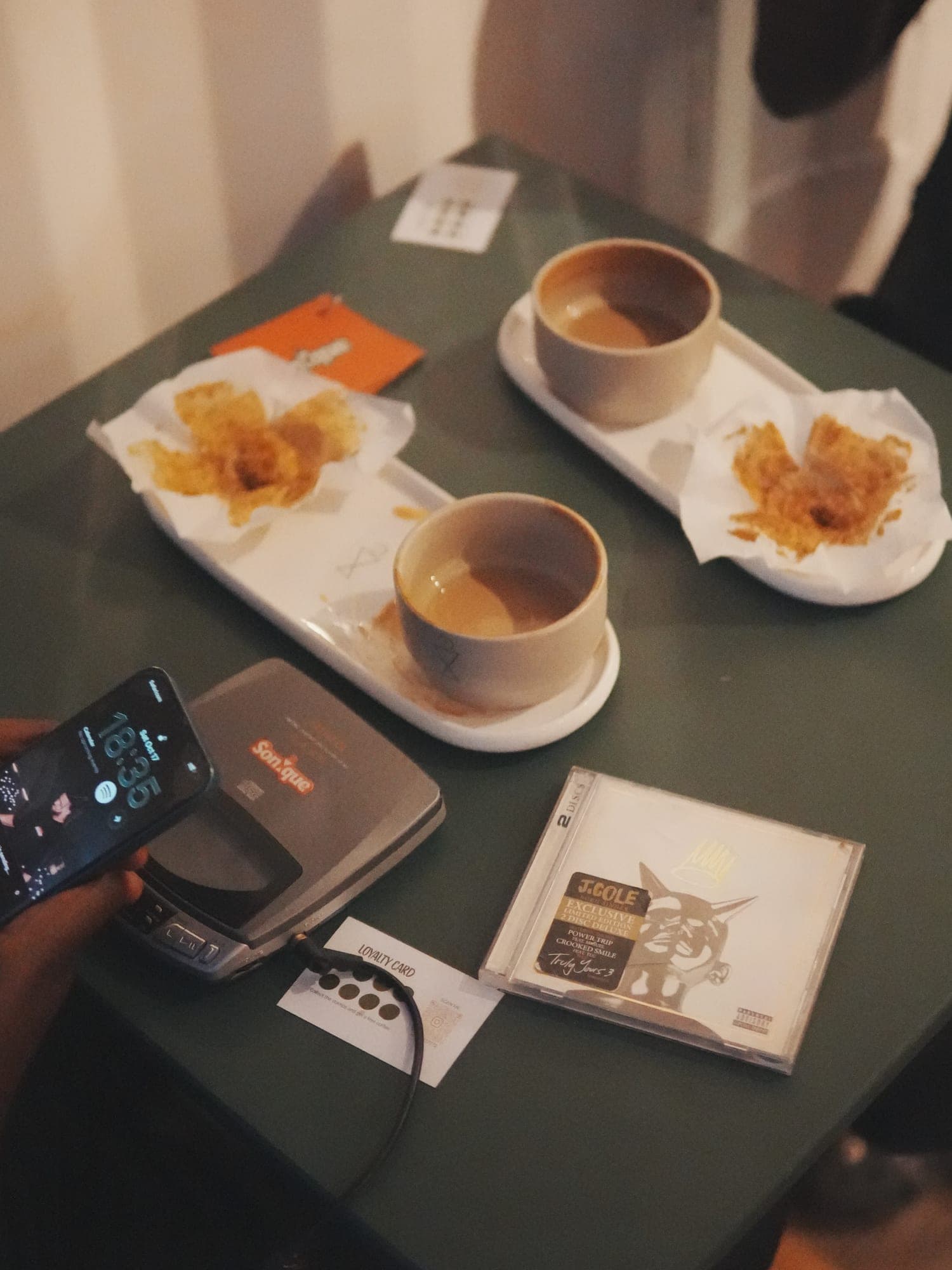 Pastries and coffee beside a CD player at Sonique
