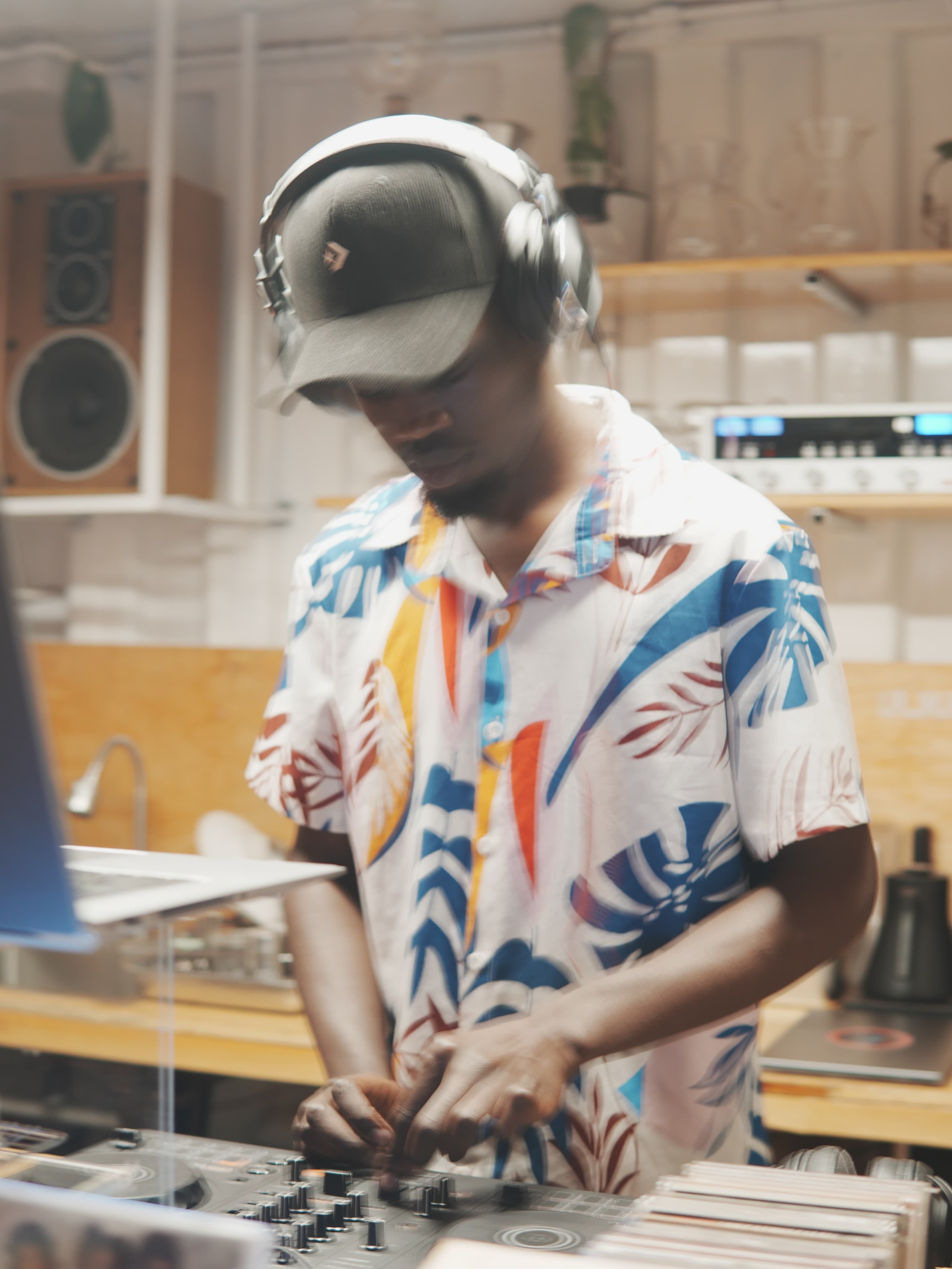 A DJ in headphones at the Sonique decks, surrounded by CDs